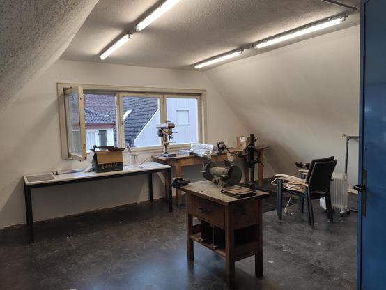 In einem Zimmer im Dachgeschosse befinden sich Metallbearbeitungsmaschinen (Standbohrmaschine, Schleifer, Schraubstock, usw.)